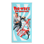 Pee-wee’s Big Adventure beach towel with Pee-wee Herman on his red bicycle over a blue and white sunburst background.